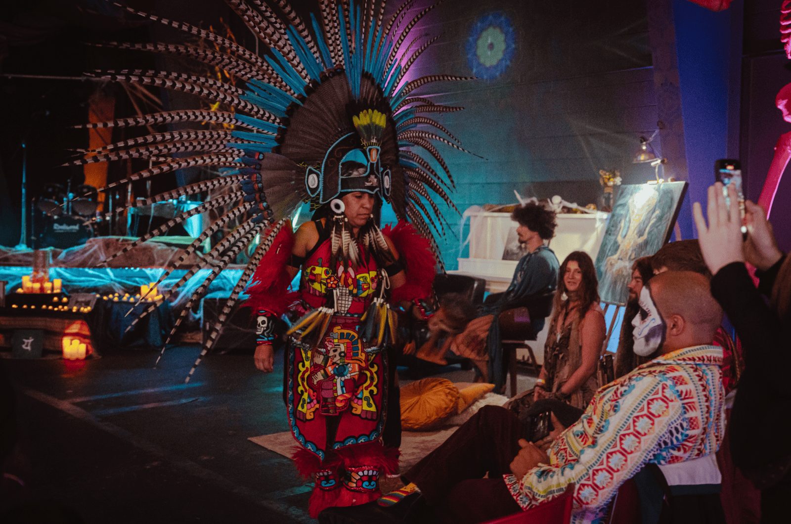 A performer in an elaborate feathered headdress at a Haven gathering