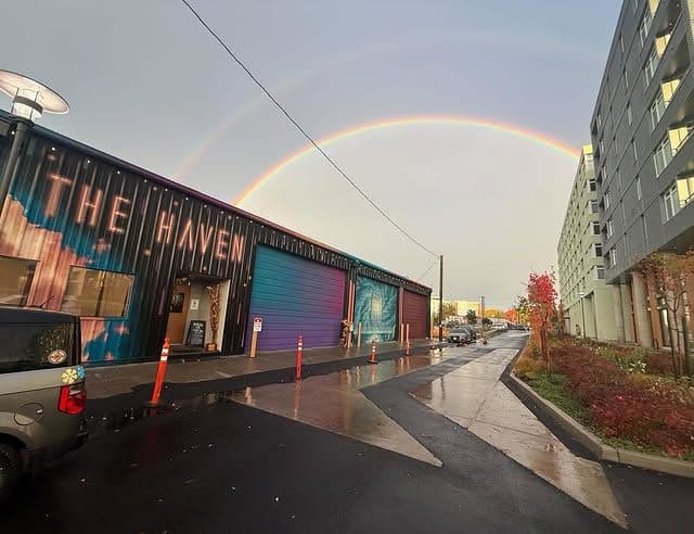 The Haven warehouse seen from the street with a rainbow overhead