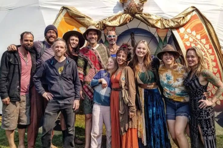 Members of The Haven collective gathered in front of a painted backdrop